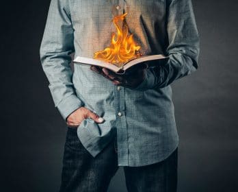 person holding book on fire
